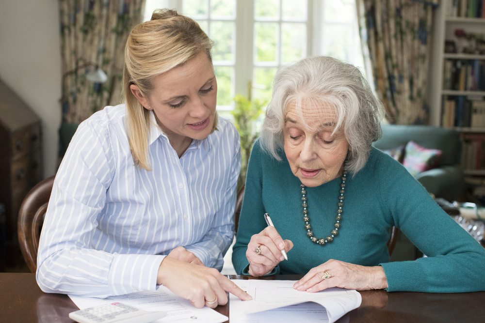 elderly women signing a document